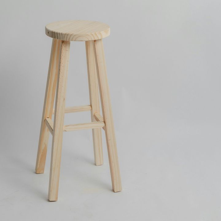 Tabouret haut en bois clair, sur fond gris